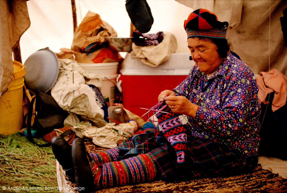 At an Innu hunting camp, Enen, knits a pair of socks in her tent. Labrador, Canada. 1997