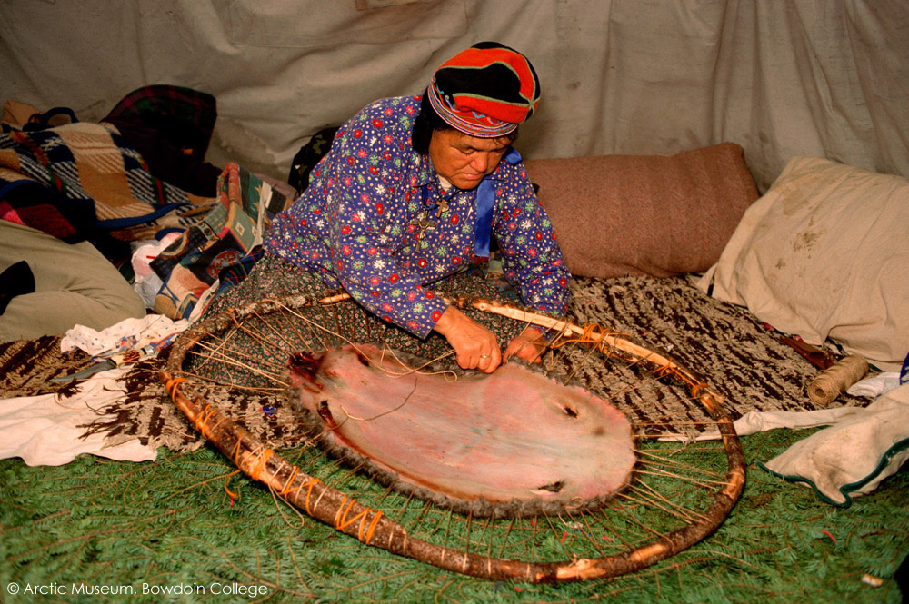 At an Innu hunting camp, Enen, laces a beaver skin onto a frame to dry. Southern Labrador, Canada. 1997
